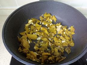 锅里放油，油热下蒜泥炒香，下酸菜翻炒均匀。