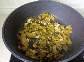 锅里放油，油热下蒜泥炒香，下酸菜翻炒均匀。