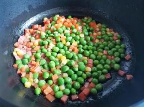 加入豌豆玉米胡萝卜翻炒几下，