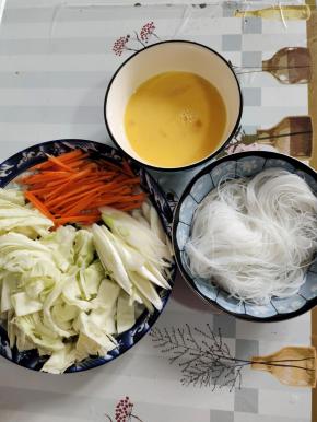包菜切成条状，胡萝卜切成丝，大葱斜切成片，鸡蛋打散，泡软的粉丝捞出沥干水分备用！