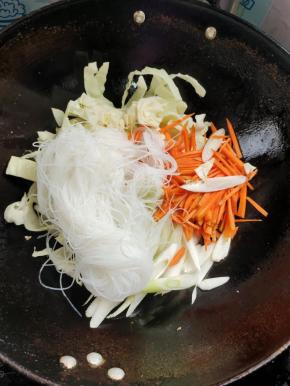 放入包菜，胡萝卜，大葱，粉丝翻炒均匀！