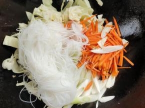 放入包菜，胡萝卜，大葱，粉丝翻炒均匀！