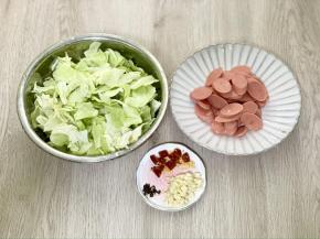 包菜洗净撕成小块，火腿肠斜着切成片，干辣椒剪成小段，大蒜切成末