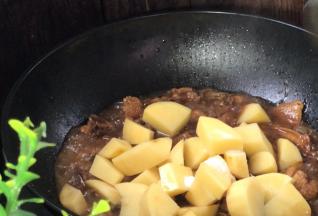 20分钟后，打开锅盖拌匀，放入土豆，加入盐拌匀，继续焖10分钟