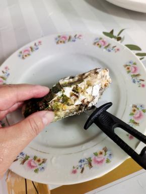 开生蚝有技巧！生蚝有一面鼓起来，有一面平面！平面朝上，它的主要衔接点就在这个位置，用刀尖把衔接点切段！