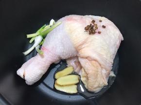 锅里放入鸡腿，姜片，花椒粒，葱白段