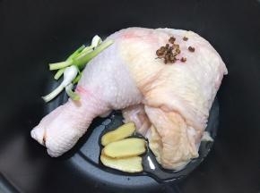 锅里放入鸡腿，姜片，花椒粒，葱白段