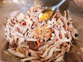 把调好的料汁倒入鸡肉里，淋上一大勺红油辣椒和适量花椒油