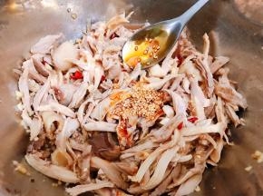 把调好的料汁倒入鸡肉里，淋上一大勺红油辣椒和适量花椒油