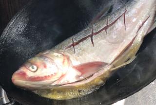 歪着锅尽量将鱼头煎香