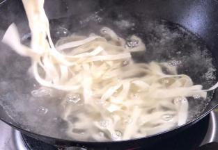 焖煮酱料的期间，我们来煮面，将手工面放入开水锅中煮熟