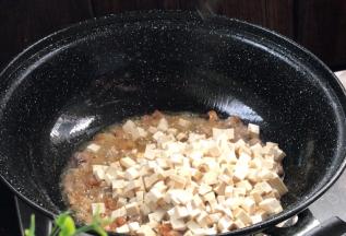 加入豆干，炒至表面微黄