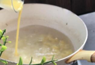 在沸腾前，淋入蛋黄液，边淋边搅拌均匀