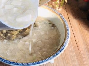 双手端起两种汤，同时对角倒入碗中