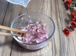 再加少许清水，搅拌至上劲，腌制备用