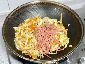 接着下入火腿肠丝翻炒