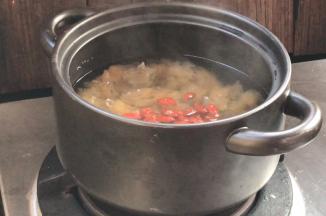 半小时后银耳煮至汤汁浓稠，加入冰糖和枸杞