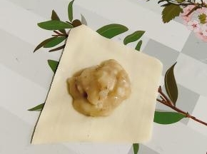 取一张饺子皮，再放入适量的香蕉泥！