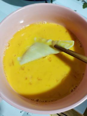 把香蕉派生胚放入蛋液中，均匀的裹满鸡蛋液！