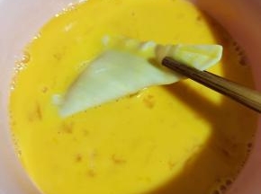 把香蕉派生胚放入蛋液中，均匀的裹满鸡蛋液！