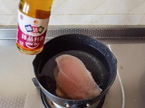 干净不粘锅中倒入半锅清水，放入鸡胸肉片，淋3勺料酒去腥，大火煮开后将鸡胸肉煮熟。