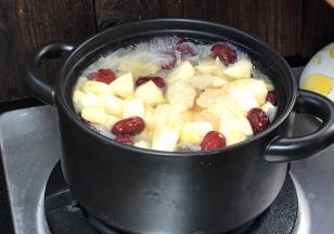 半小时后，将苹果和冰糖加入炖锅中，拌匀