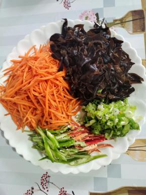 青红辣椒切成丝，胡萝卜切成丝，木耳提前泡发好，切成丝！葱切成葱花备用！
