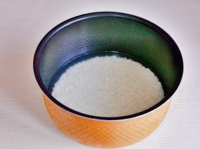 大米淘干净倒入电饭煲中，加入平时烧饭的水量。