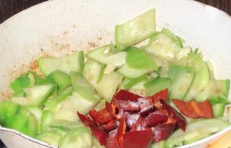 加入红椒、盐炒匀入味，再同丝瓜一起翻炒均匀