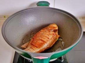 起油锅，加入腌制好的鲈鱼中火煎至两面金黄。