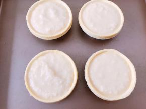 把做好的椰蓉馅料用勺子装入蛋挞皮里，放入烤箱中层180度烤25分钟表面金黄即可