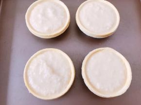 把做好的椰蓉馅料用勺子装入蛋挞皮里，放入烤箱中层180度烤25分钟表面金黄即可
