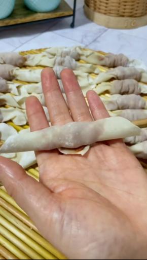 筷子放在馄饨皮一头的顶端，卷起来！
