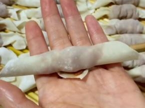 筷子放在馄饨皮一头的顶端，卷起来！