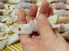用手抓住馄饨，抽出筷子，一个糖果小馄饨就包好了！