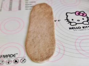 取一块面团，擀长舌状。