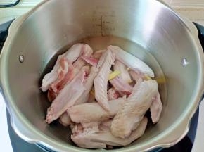 锅里放适量的清水，加入鸭翅，生姜片。