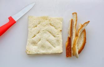 吐司去四边，擀成薄片，分两边各斜划三刀。四周涂上蛋液。