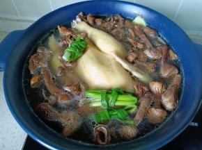 焯好水的三黄鸡重新放入砂锅，一次性加好水，放入泡好的菇，葱结。