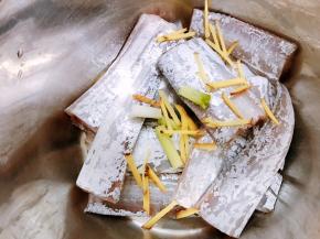 沥干水的带鱼放入盆里，加入姜丝和葱白段