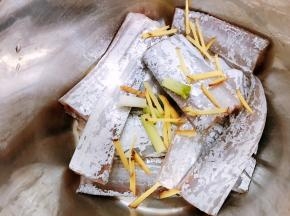 沥干水的带鱼放入盆里，加入姜丝和葱白段