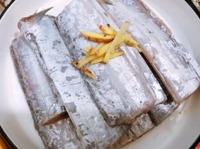 把腌制好的带鱼摆入蒸盘里，重新放上姜丝