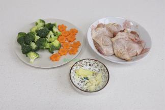 食材的准备：鸡腿清洗干净，去皮骨头，鸡皮不要切断哦。然后放少许黄肖氏香辣酱汁，用手揉搓腌制。胡萝卜去皮，切成花形状，西兰花切小朵，清洗干净。生姜、大蒜也切好备用。