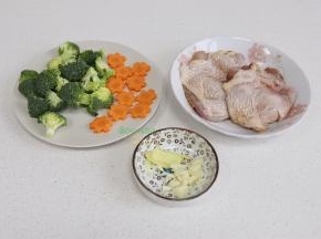 食材的准备：鸡腿清洗干净，去皮骨头，鸡皮不要切断哦。然后放少许黄肖氏香辣酱汁，用手揉搓腌制。胡萝卜去皮，切成花形状，西兰花切小朵，清洗干净。生姜、大蒜也切好备用。