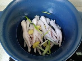 鸡爪冷水放入砂锅，加葱姜，料酒焯水。