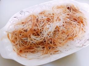 蒸盘里铺上泡软的粉丝，淋上调好的料汁