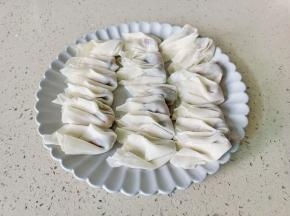 取一张馄饨皮加一点馅包起来。