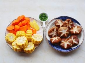 香菇洗净打花刀，玉米切块，胡萝卜切段泡入水中，