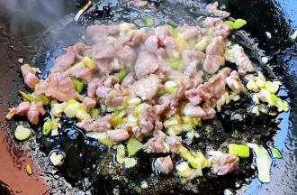 放入鲜猪肉炒至变色入味