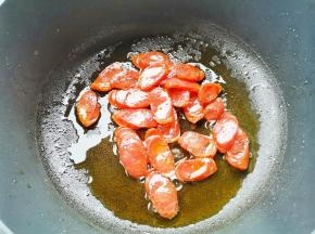 热锅热油，加腊肠炒至变色，